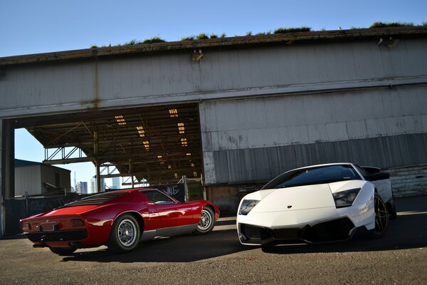 Cars red and white parked in the middle of an abandoned building