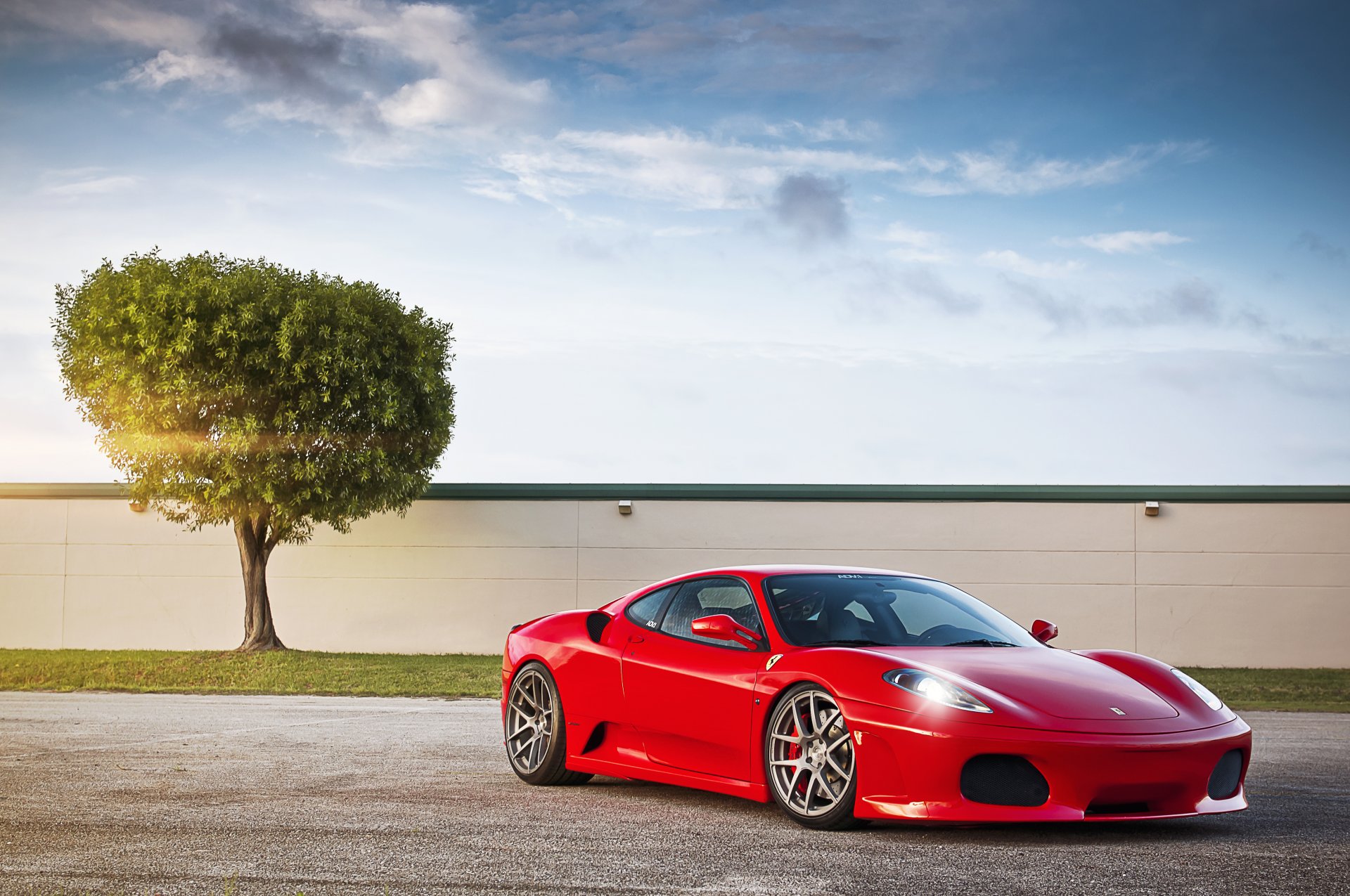 ferrari f430 czerwony ferrara czerwony drzewo niebo chmury słońce blask