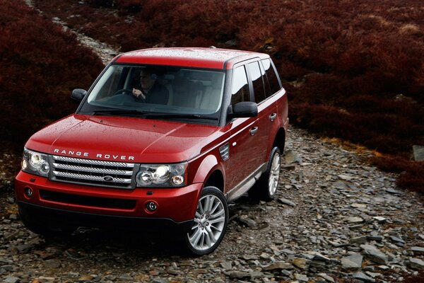 Red range Rover en un camino rocoso