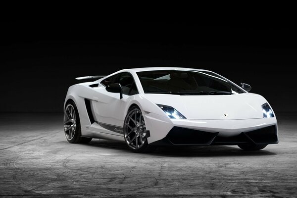 Vue de face de la voiture de sport blanc Lamborghini dans la nuit