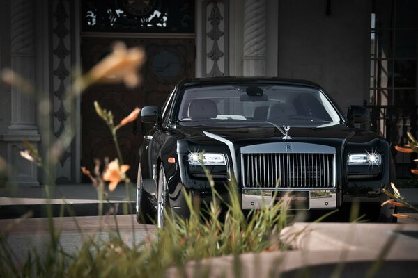 Coche negro de Rolls Royce en el fondo de la casa