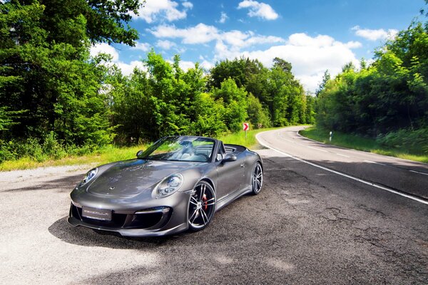 Convertible on the side of the road in the woods during the day