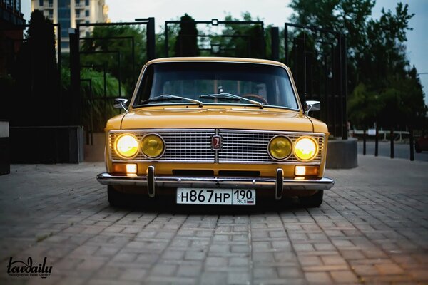 Brick pavement and nostalgia, yellow old Lada