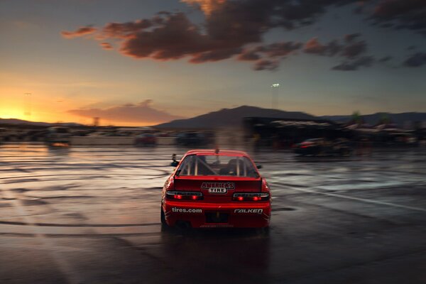 Voiture de sport rouge à la lumière du coucher de soleil pourpre