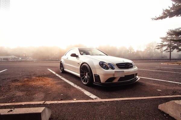 Mercedes auf dem Parkplatz vor dem Hintergrund eines Waldes im dichten Nebel