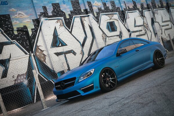 Mercedes-benz with cool tuning on the background of graffiti at the fence