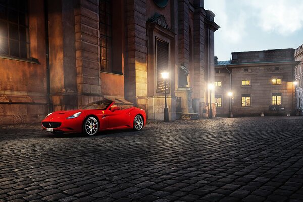 Red sports car ; on the street of the city