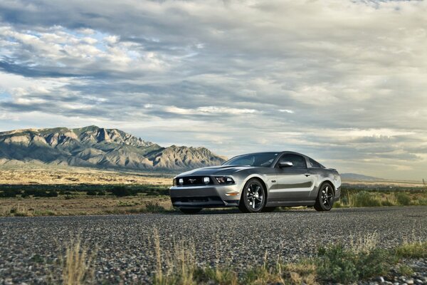 Silver Ford on the background of mountains and clouds