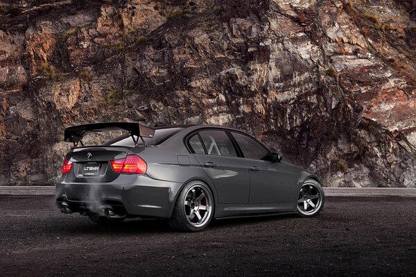 Brutal black bmw 335i 3 series rear view near the cliff