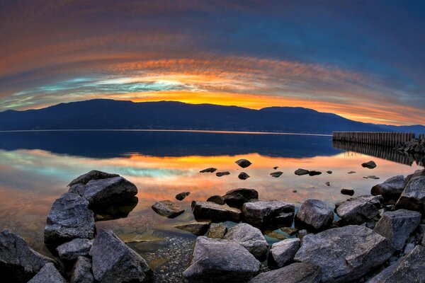 Tramonto di sera sul lago con le pietre