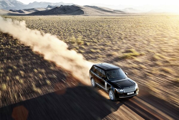 Range rover is flying at speed through the desert