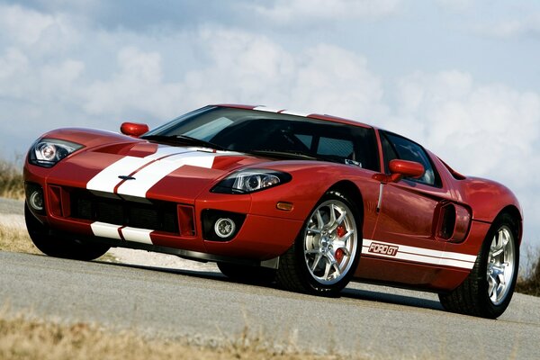 Red supercar on a cloudy sky background