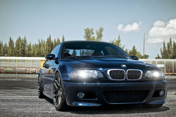 Blue tuned BMW with headlights on