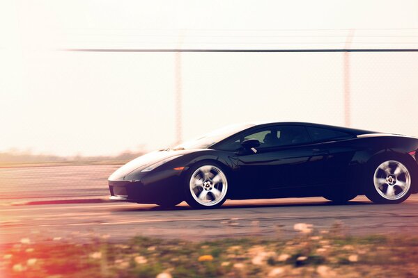 Lamborghini negro a la velocidad en la pista