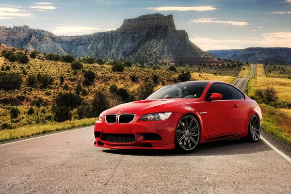 BMW rojo tuneado en la carretera