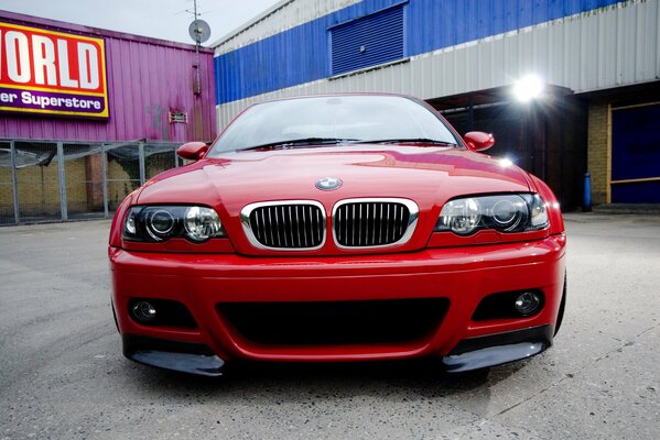 Rotes BMW-Auto auf Hofhintergrund und Flutlicht