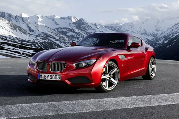 A red bmw stands against the background of mountains