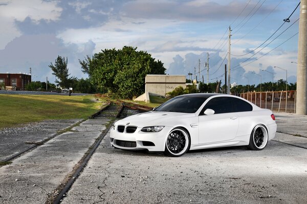 White BMW next to the power line