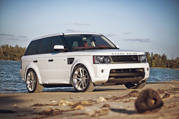 Biały sportowy range rover na plaży