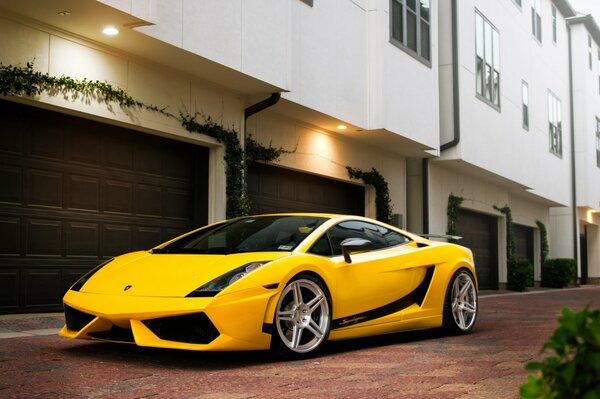 A yellow sports car is parked on a city street