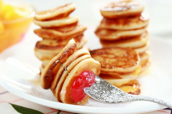 Pancakes with berries on a white saucer