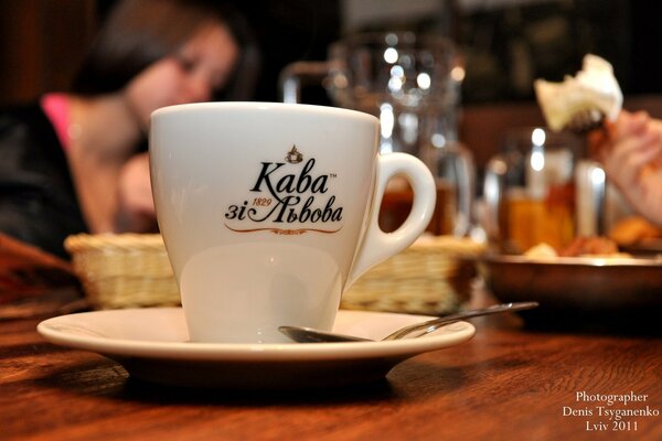 Taza de café con cuchara sobre fondo de cerveza