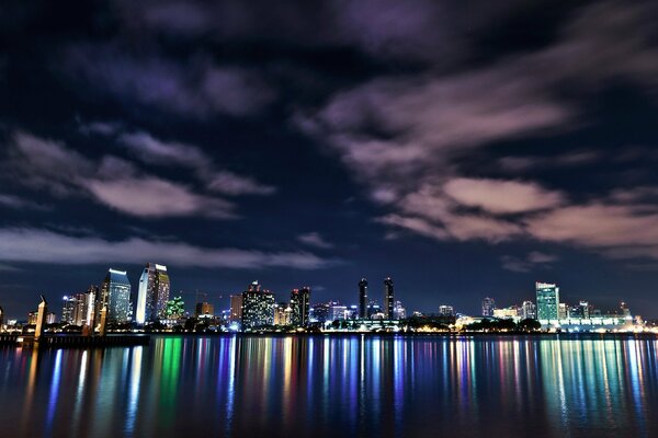 Megacities on the background of water with the reflection of a bright city in the water