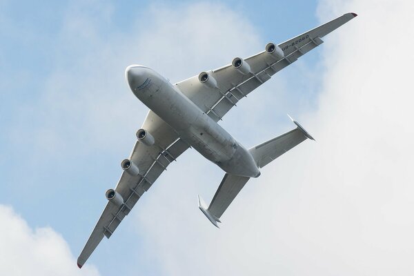 The plane is flying in the sky with clouds