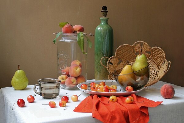 Nature morte de baies lumineuses et serviette, pêches dans un pichet transparent, poires dans une tasse