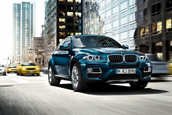 Blauer bmw x6 fährt durch die Stadt