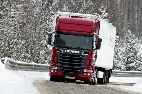 Red scania truck on a snowy highway