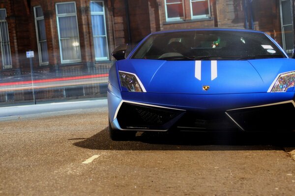 A beautiful, blue car is driving along the road