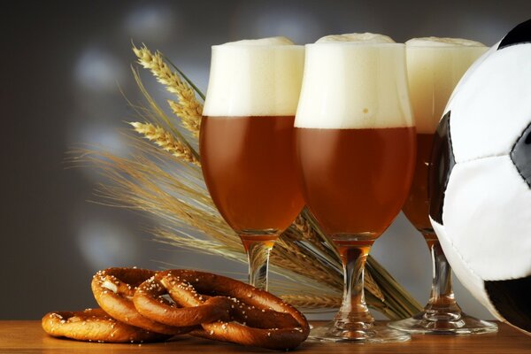 Still life on a football theme with beer, pretzels and a black and white ball