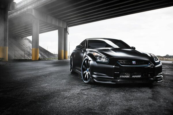 Voiture noire nissan GTR sous le pont