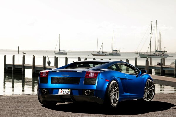 Une Lamborghini Gallardo bleue se dresse sur le quai