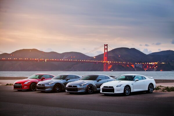 Several cars stand against the background of the bridge in San Francisco