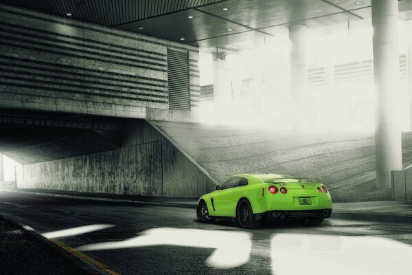 Green Nissan tuned on the background of buildings