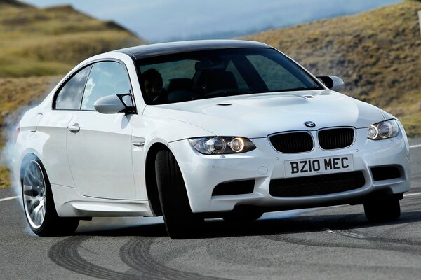 White BMW performs a smoke drift trick