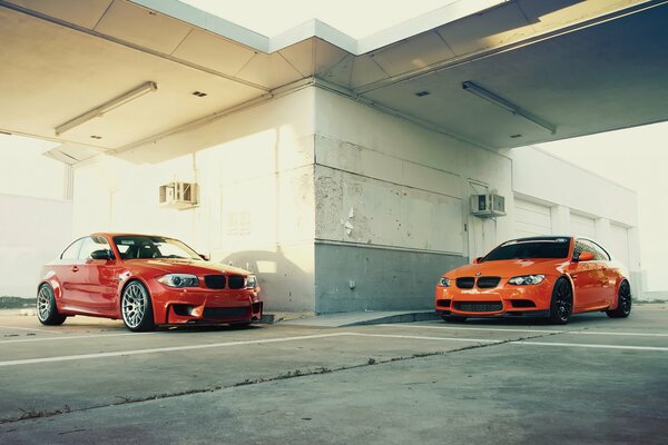 Two red bmw m3 and 1m in the parking lot