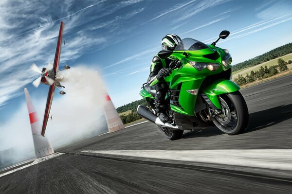 Green kawasaki eats on the background of a falling plane