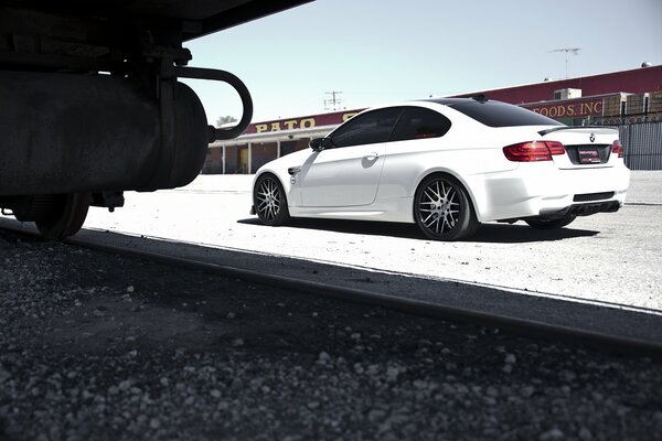 Weißer BMW neben Eisenbahnschienen