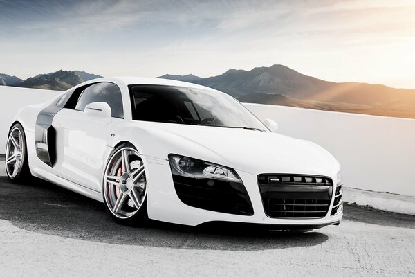 Superdeportivo blanco audi, r8 v10 en el fondo de las montañas