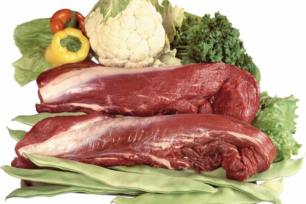 Two large pieces of meat next to vegetables