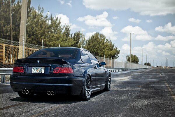 Black BMW on the road, rear view