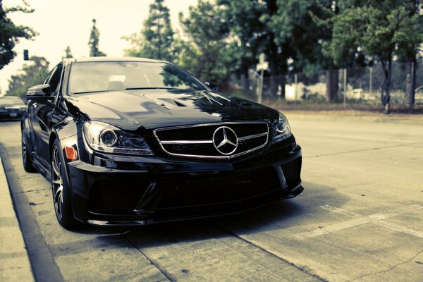 Noir Mercedes C63 debout dans la rue