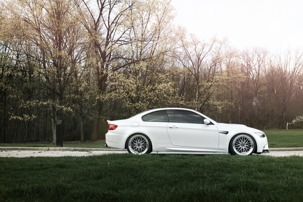 Weißes Auto BMW e92 auf der Straße im Herbst