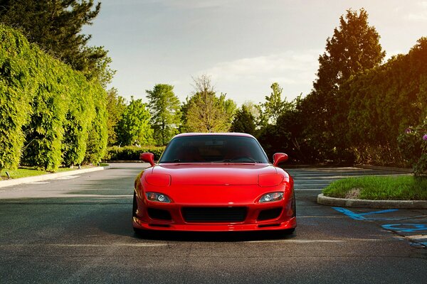 Red Mazda sta sulla strada in giardino