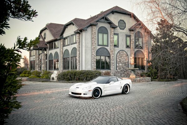 Chevrolet Corvette in weißer Farbe auf dem Hintergrund des Herrenhauses