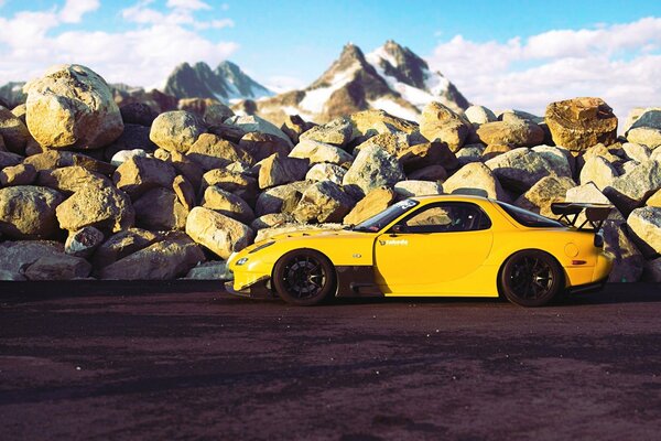 Mazda jaune tuning sur le terrain dans les montagnes