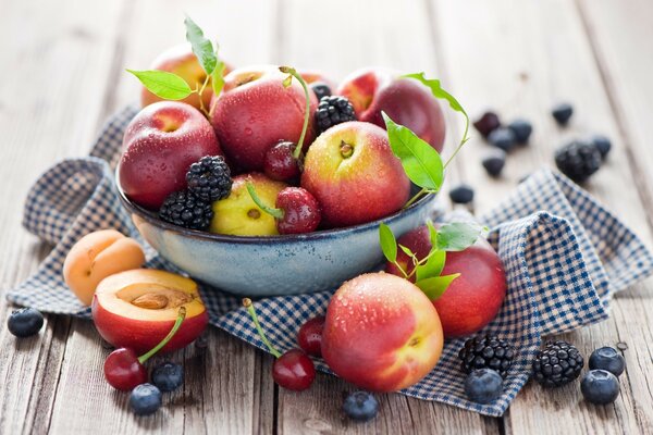 Un sacco di frutta in un piatto e su un tovagliolo a scacchi